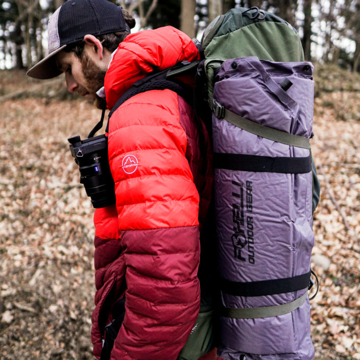 Foxelli camping pad strapped onto Sam's backpack